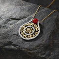 A striking gold-tone pendant featuring an intricate circular design. Its detailed finish gives the piece a luxurious and timeless appearance.