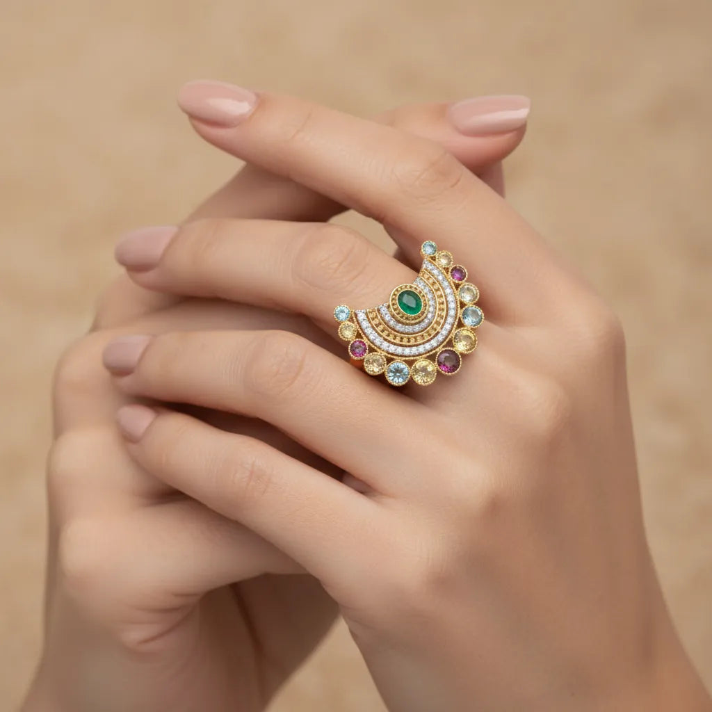 A distinctive ring featuring a beautiful green center stone surrounded by delicate detailing. A graceful statement piece designed to add a touch of color and elegance to your look.