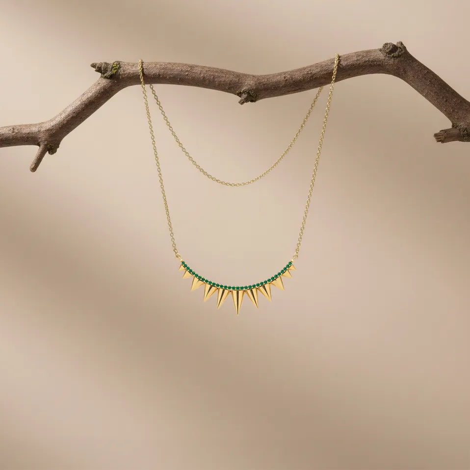 A graceful layered necklace featuring fine chains and subtle pendant details. Its minimalist design makes it perfect for everyday elegance and effortless with green layering.