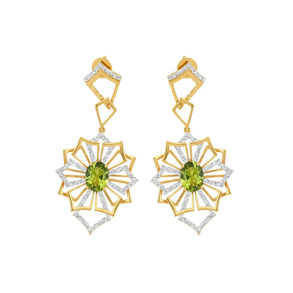 A pair of gold drop earrings with a geometric sunburst design, featuring green peridot gemstones in the center and clear pavé-set stones along the edges, shown on a plain white background.
